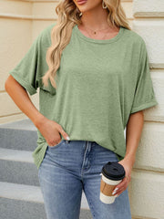 Relaxed fit green t-shirt with rolled sleeves and crew neck, worn by a woman with jeans.