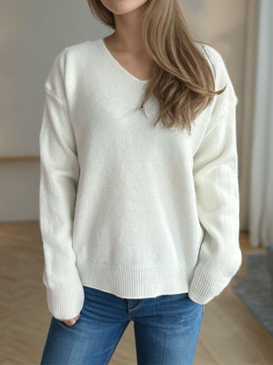 White relaxed-fit V-neck knit sweater with ribbed hem and cuffs, acrylic material.