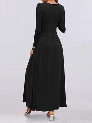 Black ruched maxi dress with long sleeves, empire waist, and pockets.