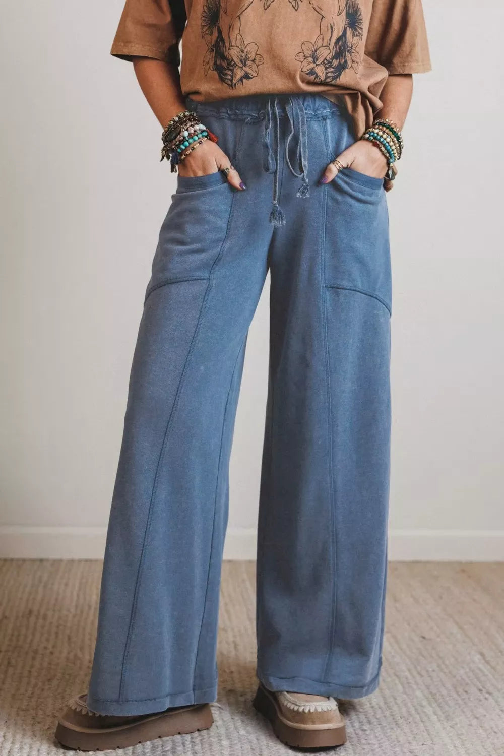 Blue denim maternity pants with drawstring waist and wide legs.
