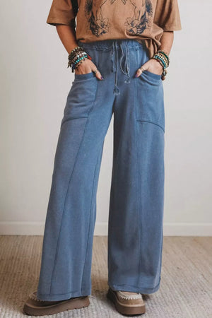 Blue denim maternity pants with drawstring waist and wide legs.