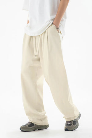 Ivory wide-leg pleated drawstring trousers with a casual fit.