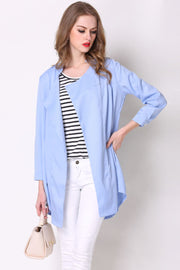 Light blue drape-front trench coat with shoulder detailing and buttoned cuffs.