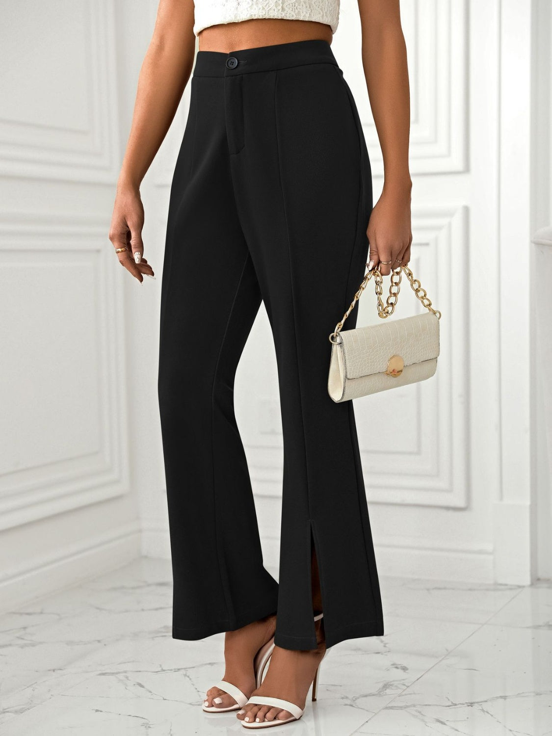 Black tailored flare trousers with split hems and a high waist.