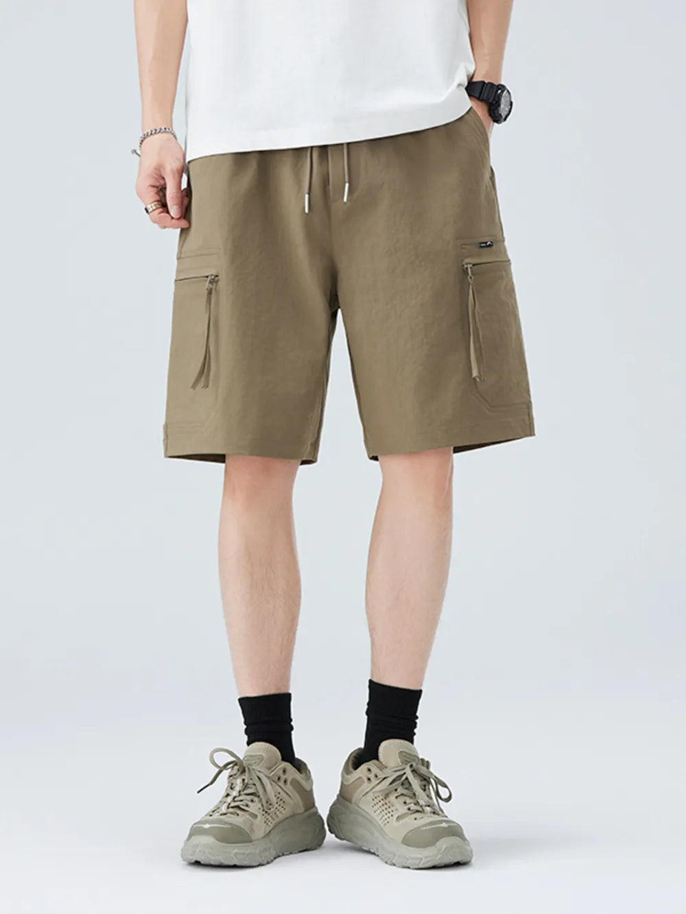 Men's camel cargo shorts with zippered pockets and drawstring waist.