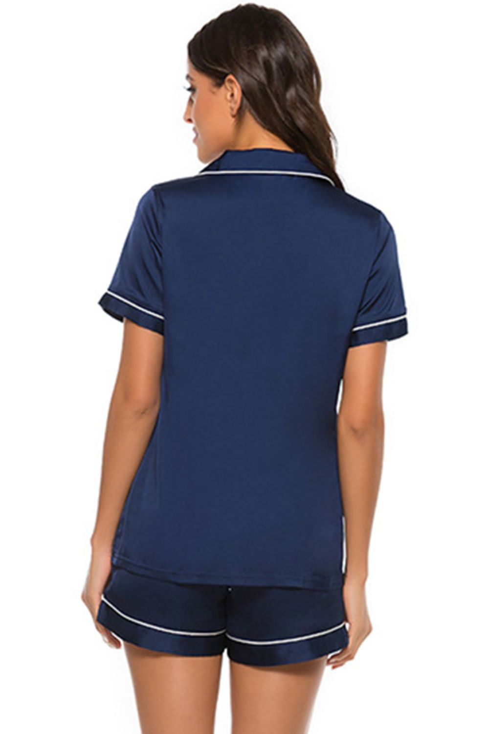 Dark blue satin pajama set with white piping, short sleeves, and shorts.