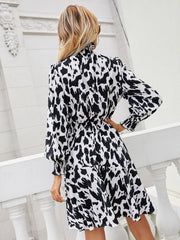 Abstract print midi dress with shirred waist and ruffled cuffs.