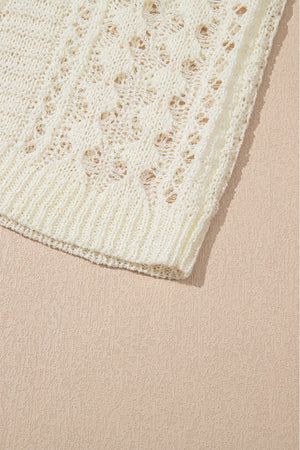 Beige openwork knit beach cover-up with a textured pattern and ribbed hem.