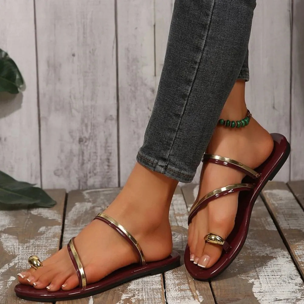 Burgundy thong sandals with metallic trim and toe ring detail.