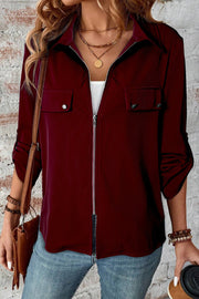 Burgundy utility blouse with zip front, chest pockets, and rolled sleeves.