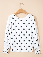 White polka dot blouse with smocked cuffs and long sleeves.