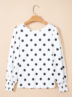 White polka dot blouse with smocked cuffs and long sleeves.