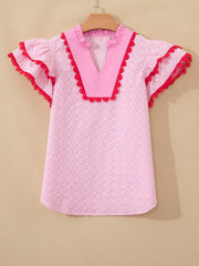 Pink eyelet embroidered blouse with flutter sleeves and red lace trim.