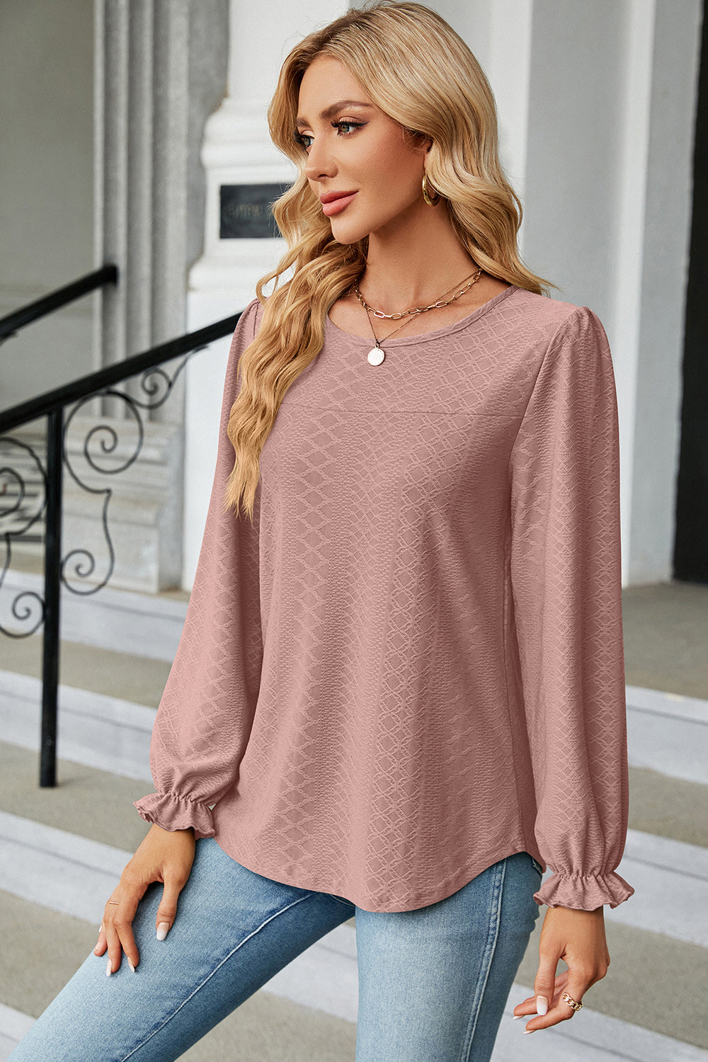 Textured puff sleeve blouse in blush pink with ruffled cuffs.