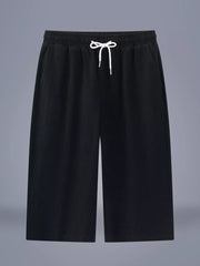 Black relaxed fit cropped sweatpants with drawstring waist and pockets.