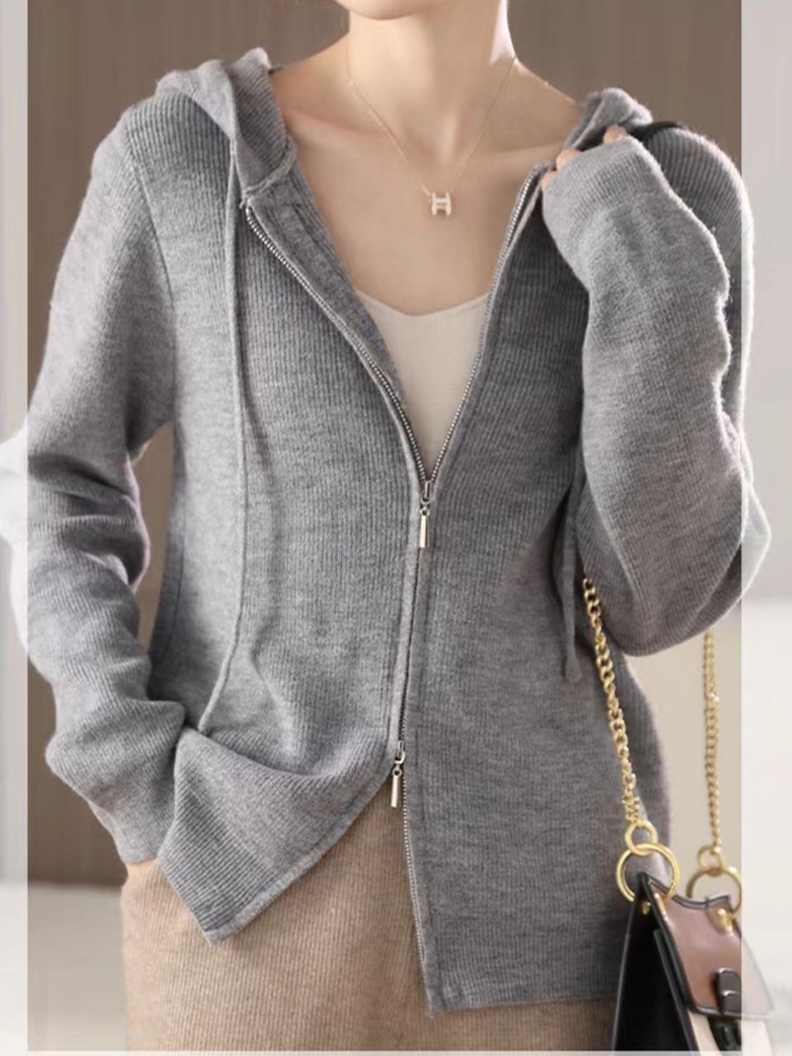 Gray ribbed knit zip-through hoodie with pockets and drawstring hood.