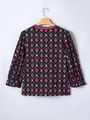 Black cotton blouse with vintage floral print, bracelet sleeves, and contrast trim neckline.