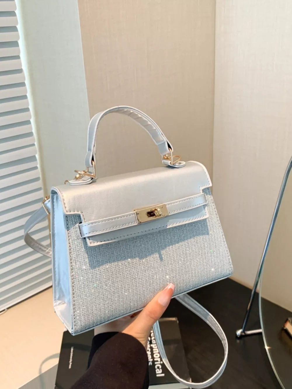 Silver glitter textured mini crossbody bag with gold hardware and top handle.