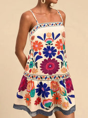 Vibrant floral print mini dress with square neckline and spaghetti straps in beige.