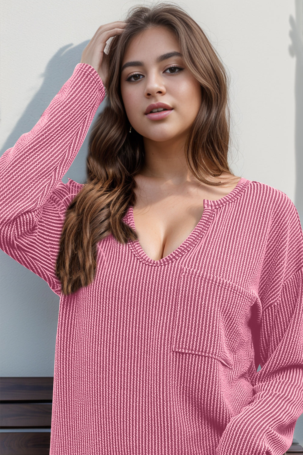 Pink ribbed plunge neck top with chest pocket and long sleeves.