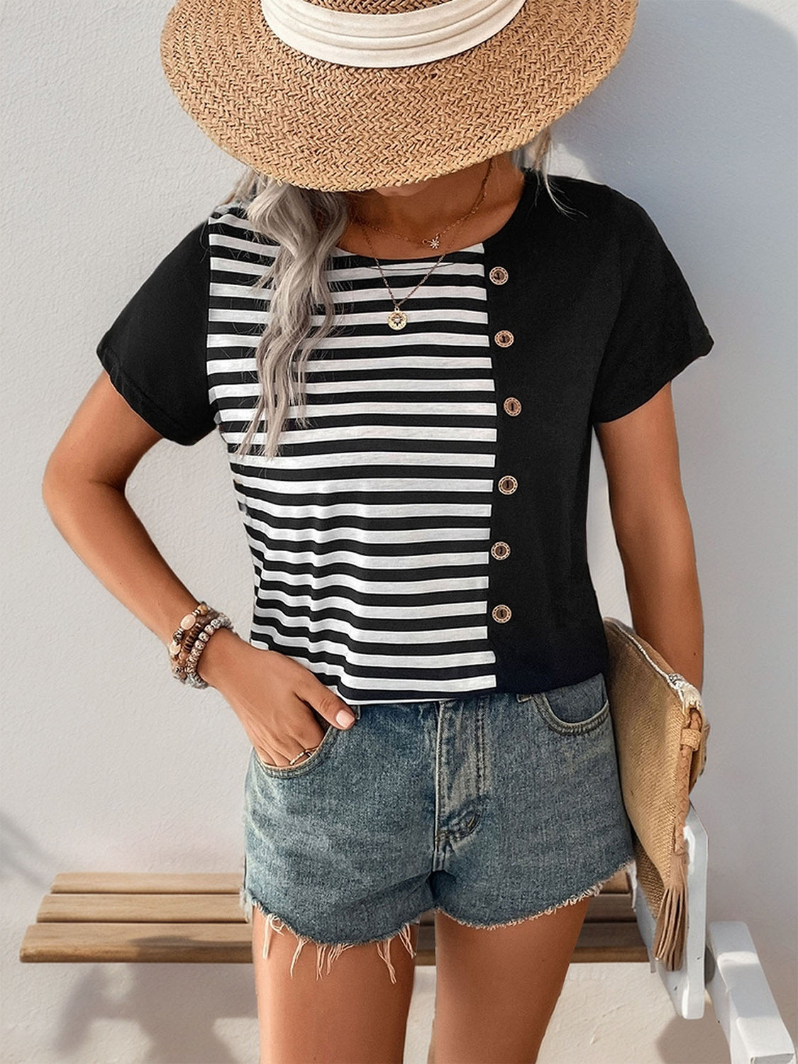 Black and white striped button-down tee with short sleeves and a round neck.