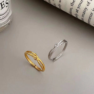Elegant knotted sterling silver ring in gold and silver, adjustable band, fine jewelry accessory.