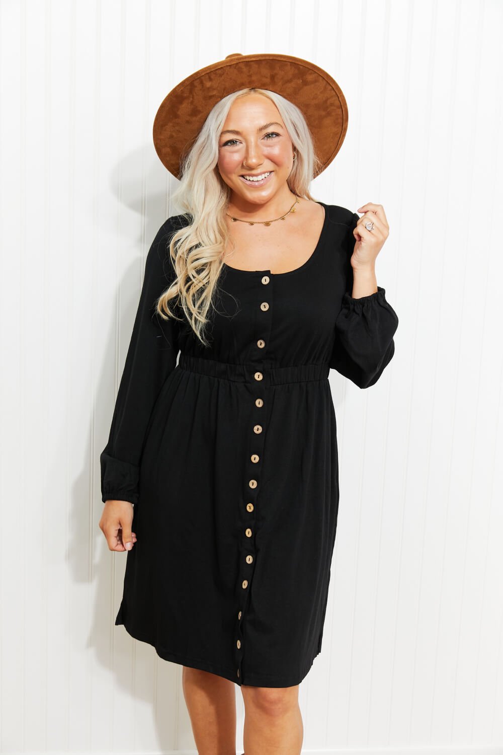 Black button-down empire waist mini dress with long sleeves and scoop neck