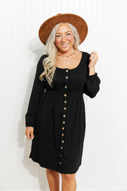 Black button-down empire waist mini dress with long sleeves and scoop neck