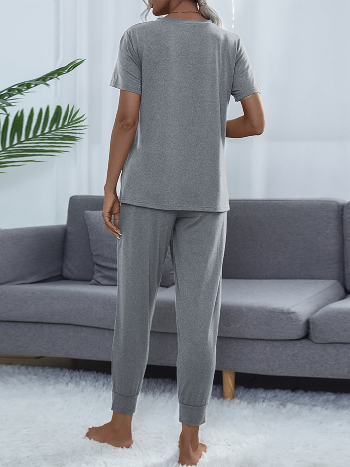 Relaxed-fit grey tee and jogger set with cuffed ankles, shown from the back.