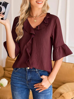 Burgundy ruffled V-neck shirt with 3/4 bell sleeves and textured fabric.