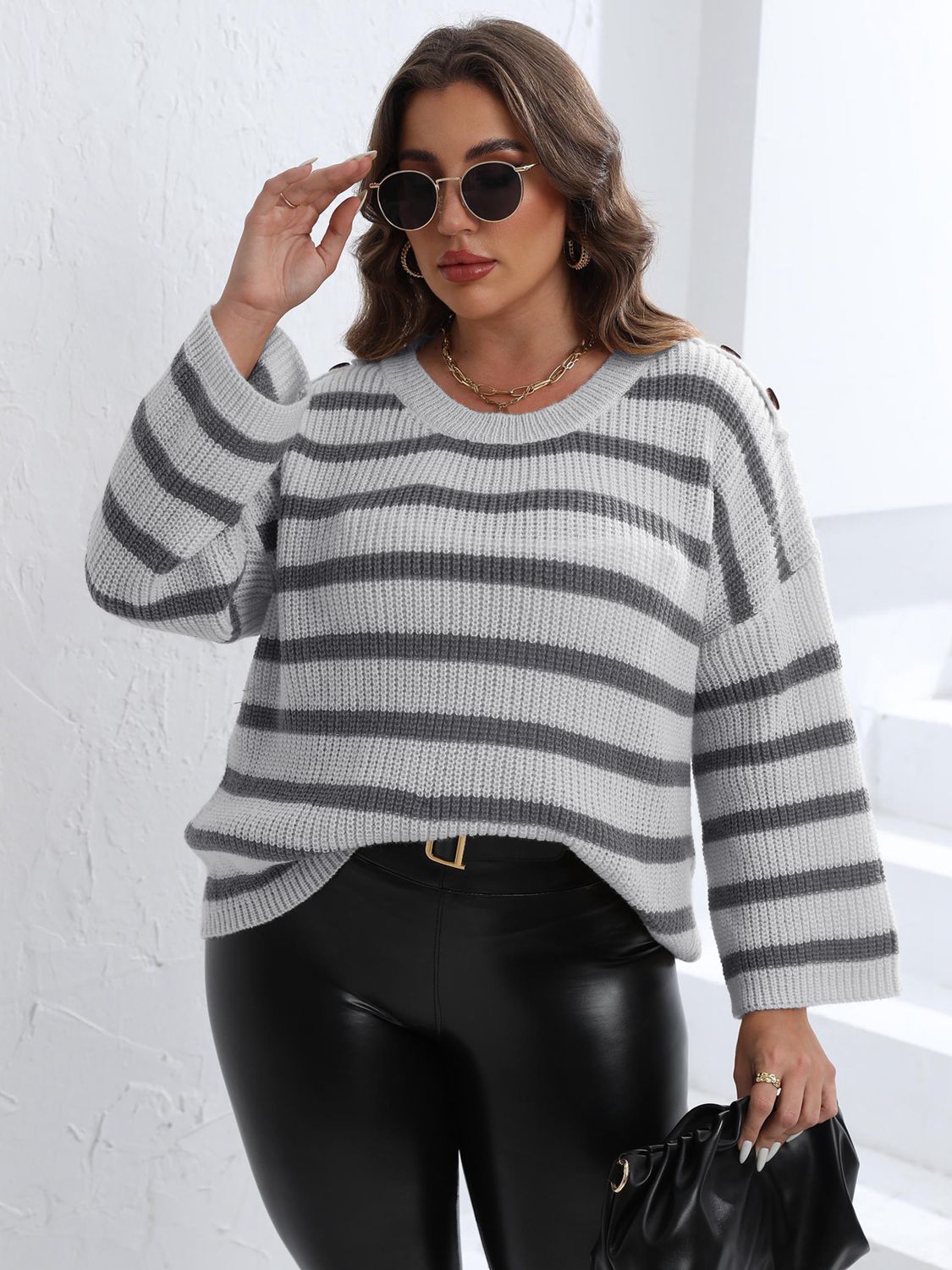 Light gray and dark gray striped knit sweater with shoulder buttons.