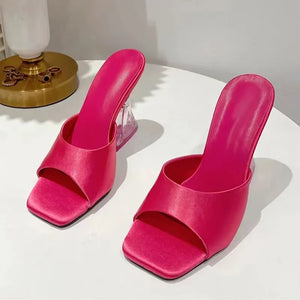 Hot Pink satin mules with a square toe and clear sculpted heel.