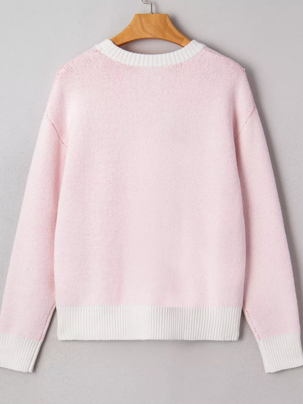 Blush pink knit sweater with white trim and ribbed hem.