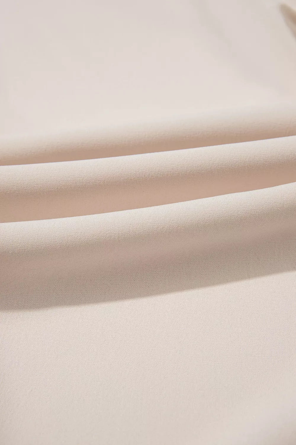 Elegant V-neck polyester blouse in a light beige, showing fabric texture and soft folds.