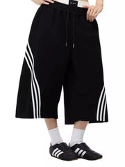 Black cropped sweatpants with white side stripes and drawstring waist.