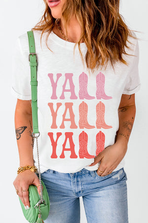 White graphic tee with "Y'all" and cowboy boot print in pink and coral tones.
