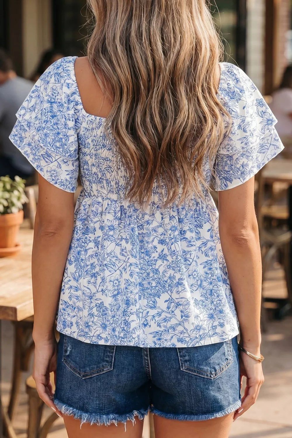 Floral ruffled sleeve babydoll shirt with smocked bodice and square neckline.
