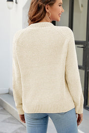 Ivory waffle knit raglan sleeve pullover sweater with mock neck and ribbed cuffs and hem.