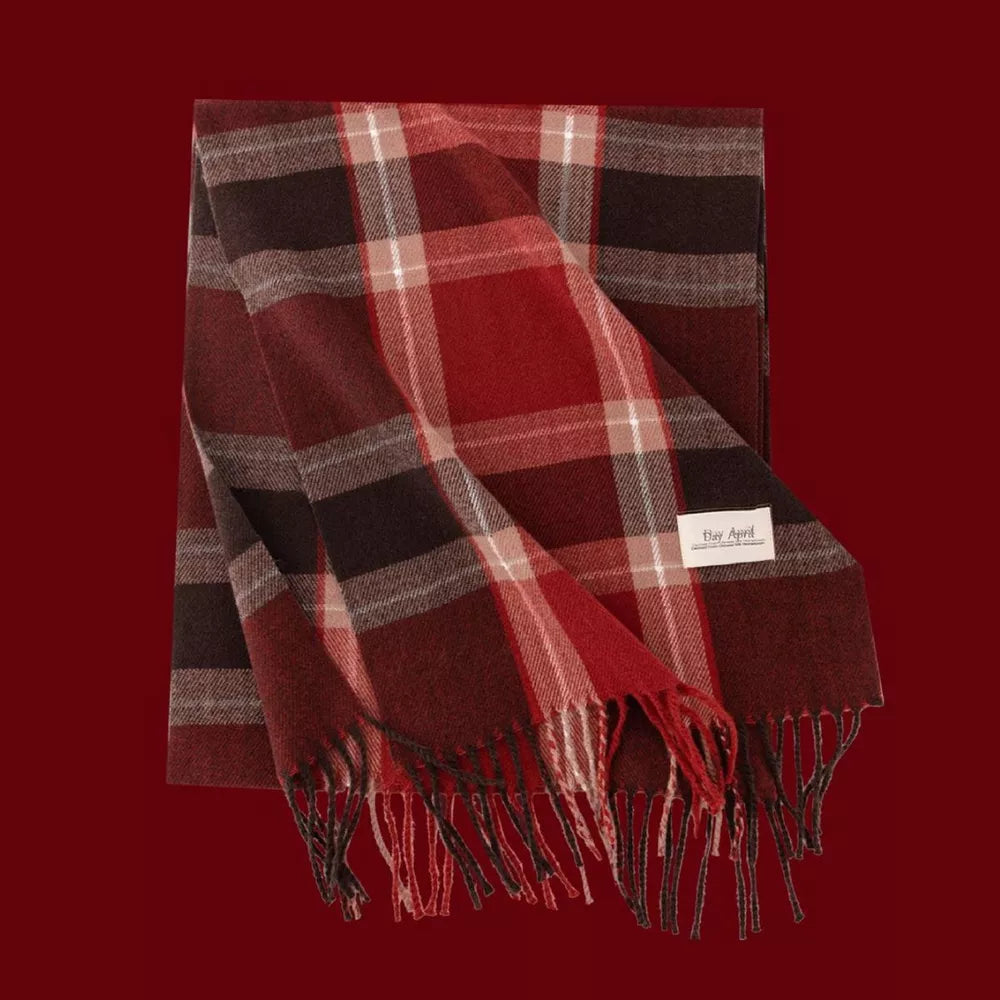 Cozy plaid scarf in red, brown, and cream with fringe details.