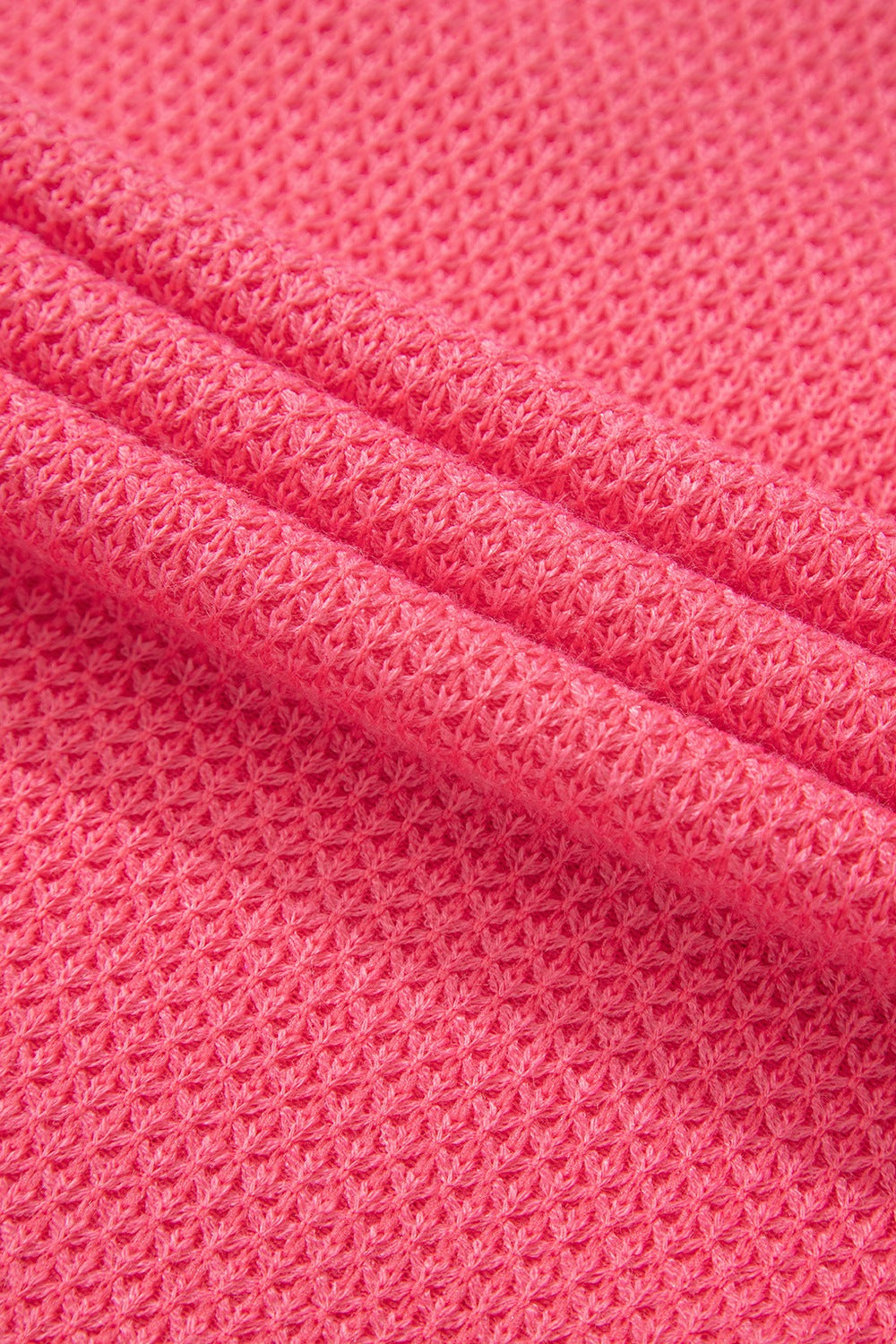 Blush pink waffle knit fabric detail of a shacket with pockets.