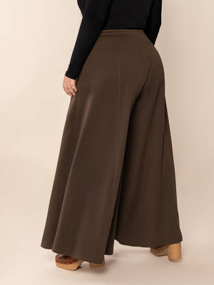 Dark brown sculpted flare palazzo trousers with a wide leg cut.
