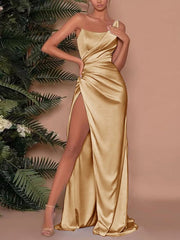 Gold one-shoulder ruched maxi dress with a high slit and satin finish.