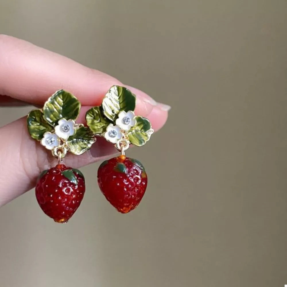 Charming strawberry dangle earrings with green leaves and white flowers.