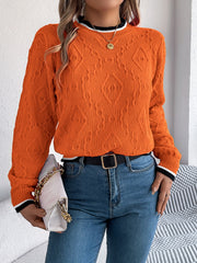 Orange diamond knit sweater with contrast trim neckline and cuffs.