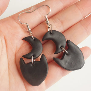 Black Halloween charm drop earrings with moon and cat shapes.