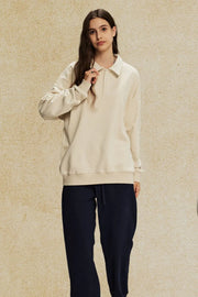 Oversized cream polo sweatshirt with collar and long sleeves, worn by a model.