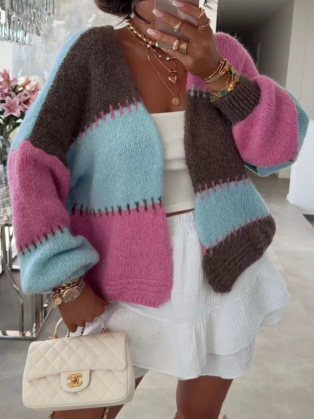 Pastel color block open front cardigan with balloon sleeves, worn with a white top and skirt.