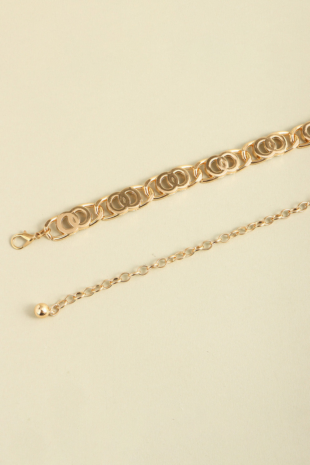 Golden chain belt with interlocking circle links and adjustable extender chain.