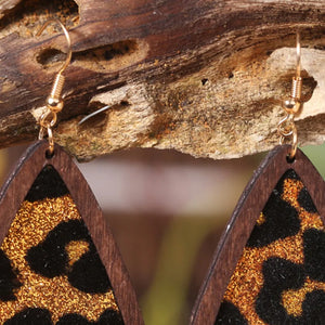 Wood-framed teardrop earrings with leopard glitter detail and gold hooks.