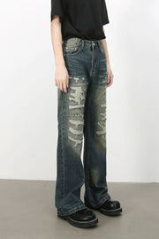 Distressed flare jeans in medium wash denim with ripped details and a worn look.